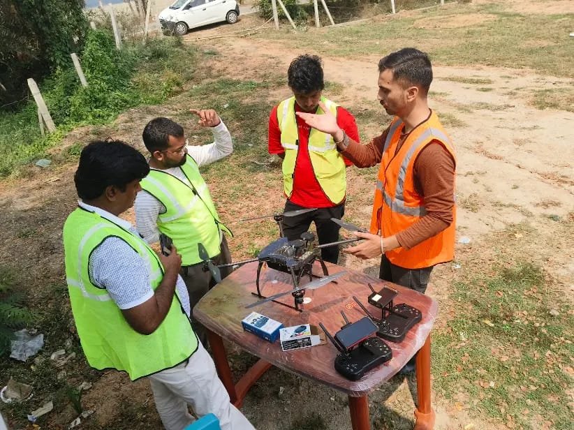 Team gathered around a table briefing on drone equipment before a field mission