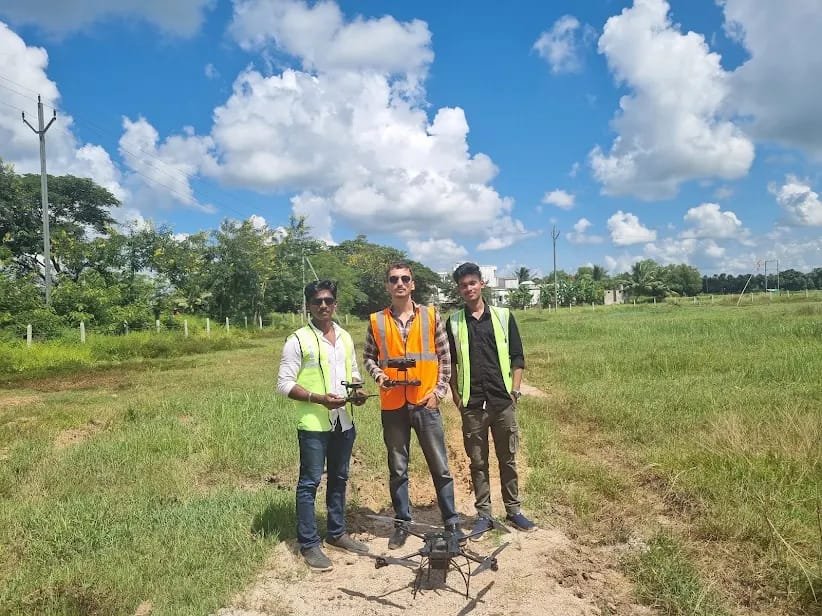 Survey team standing in an open field with an agricultural rotorcraft drone, ready for a mapping mission
