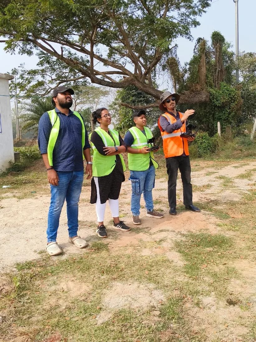 Instructor and trainees in high-visibility vests during supervised outdoor flight training